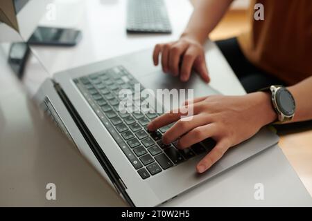 Hands of developer working on laptop at his desk in home office Stock Photo