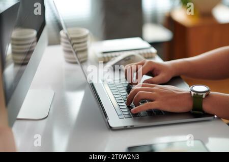 Hands of software developer coding on laptop at home Stock Photo