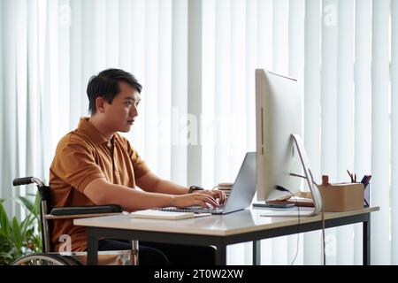 Young man with disability working as software developer at home Stock Photo