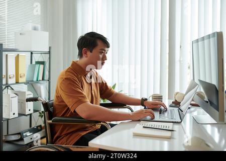 Serious young businessman working on computer in his home office Stock Photo