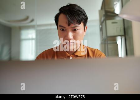 Pensive software developer searching for bugs in programming code Stock Photo