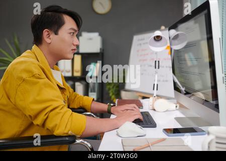 Young man with disability working as software developer Stock Photo