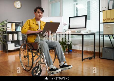 Young man with disability working on startup in his office Stock Photo