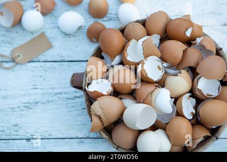 10 February 2023: Easter, broken eggs shells on light wood in a basket *** Ostern, zerbrochene Eier Schalen auf hellem Holz in einem Korb Stock Photo