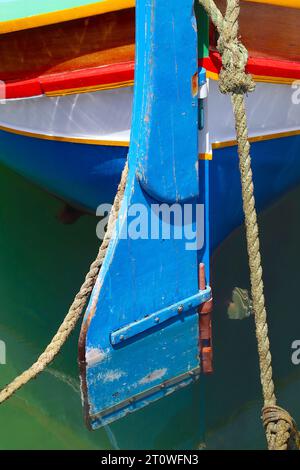 The rudder and stern of a traditionally painted xprunara or Maltese Luzzu, moored at Marsalforn, on the Maltese island of Gozo, June 2022. Stock Photo