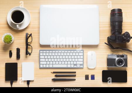 wood desk office with laptop, smartphone and other work supplies with cup of coffee. Top view with copy space for input the text. Designer workspace o Stock Photo