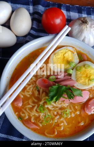 Photo of noodle soup with toppings such as sausages, eggs, and vegetables Stock Photo