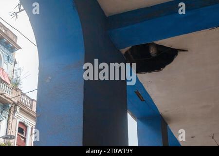 A hole in the ceiling of a building porch. The column and walls are dirty. No people in the architecture scene. Stock Photo