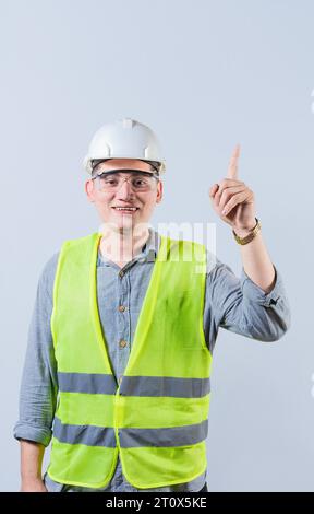 Latin engineer pointing up isolated. Smiling engineer pointing at an advertisement up Stock Photo