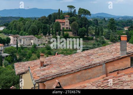 Panoramic high level view over the outskirts of the town of Lari, Italy with typical roofs with red clay tiles and Tuscan landscape Stock Photo