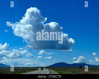 Cumulus clouds against a perfect blue sky over a Colorado byway Stock Photo