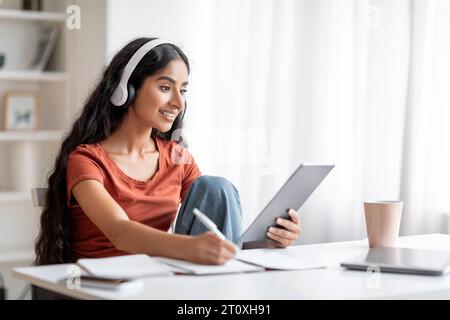 Student Young Indian Woman Using Digital Tablet, Headphones Stock Photo
