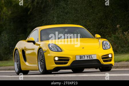 Bicester,Oxon.,UK - Oct 8th 2023: 2013 yellow Porsche Cayman classic car driving on an English country road. Stock Photo