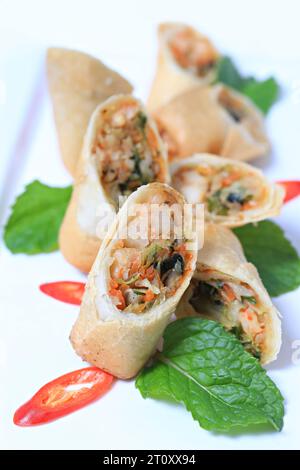 Crispy prawn spring rolls /  Crispy prawn spring rolls on white plate, Decorate with mint leaves and chili peppers Stock Photo