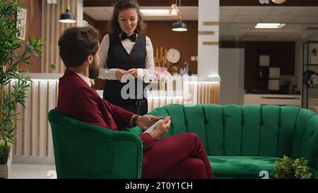 Businessman working on tablet in lobby, checking speech notes and information before official investors meeting. Important hotel guest travelling on business trip, concierge services. Handheld shot. Stock Photo