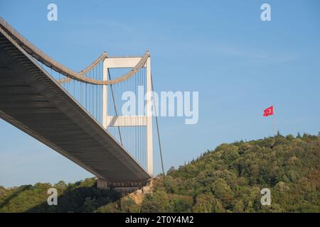 Bosphorus bridge photography from below angle with blue sky, forest and Turkish flag in İstanbul. Stock Photo