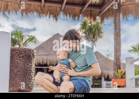 In a heartwarming outdoor scene, a caring dad and his baby share quality time, creating precious family memories amidst nature's beauty Stock Photo