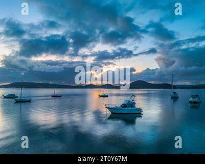 Sunrise, clouds, boats and reflections over Brisbane Water at Koolewong and Tascott on the Central Coast, NSW, Australia. Stock Photo