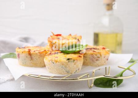 Freshly baked bacon and egg muffins with cheese on light gray table, closeup. Space for text Stock Photo
