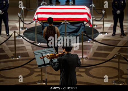 A solo violinist players while a person pauses in front of Senator Diane Feinstein's casket during her lying in state at City Hall. Stock Photo