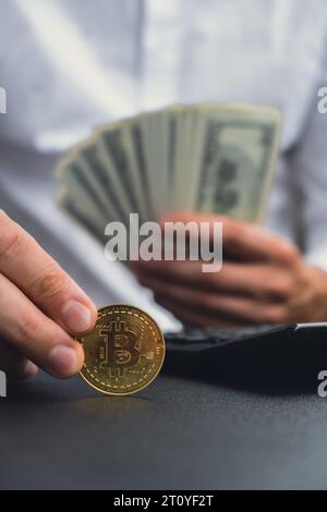 Bitcoin coin digital gold next to Expert trader hands counting income banknotes of dollar cash. Close up of hands unrecognizable Freelancer. Earned trading charts growth Cryptocurrency market investment concept. American bucks fund savings Stock Photo