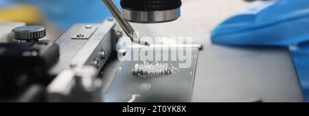Scientist examines crystals under microscope in laboratory Stock Photo