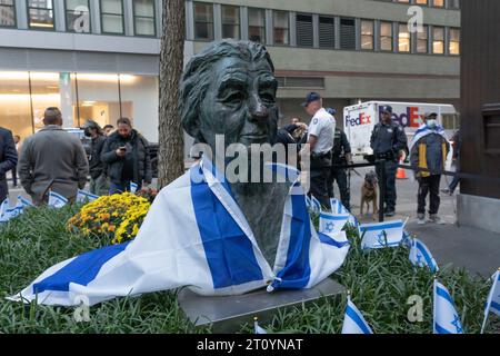 New York, USA. 09th Oct, 2023. A bronze sculpture of former Israeli prime minister Golda Meir draped with Israeli flag seen at a Candlelight Vigil for Victims of Terrorist Attacks in Israel at Manhattan's Golda Meir Square on October 9, 2023 in New York City. On October 7, the Palestinian militant group Hamas launched a surprise attack on Israel from Gaza by land, sea, and air, killing over 900 people and wounding more than 2000. According to reports, 130 Israeli soldiers and civilians have also been kidnapped by Hamas and taken into Gaza. Credit: Ron Adar/Alamy Live News Stock Photo