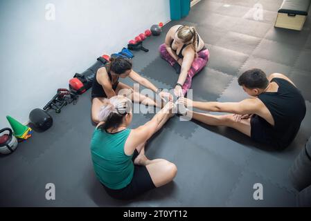 Group of 4 people all together in a circle practicing stretching to start the exercise class. Stock Photo