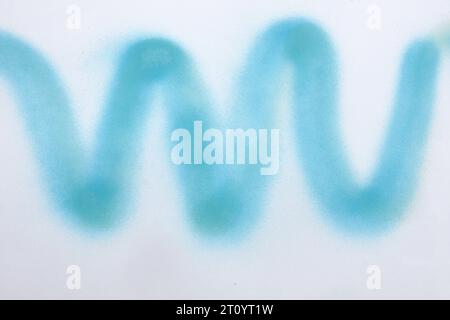 wavy line of blue spray paint on white paper background Stock Photo