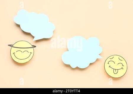 Paper faces with blank speech bubbles on beige background Stock Photo