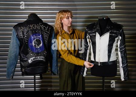 A Propstore employee adjusts Michael Jackson's custom-made leather jacket from a 1984 Pepsi New Generation commercial (estimate £200,000 - 400,000) which is next to George Michael's screen matched La Rocka Jacket (left) from the music video for 'I Knew You Were Waiting (For Me)' (estimate £30,000 - 60,000) during a preview for the Entertainment Memorabilia Auction, at the Propstore in Rickmansworth, Hertfordshire. Picture date: Wednesday September 20, 2023. Stock Photo