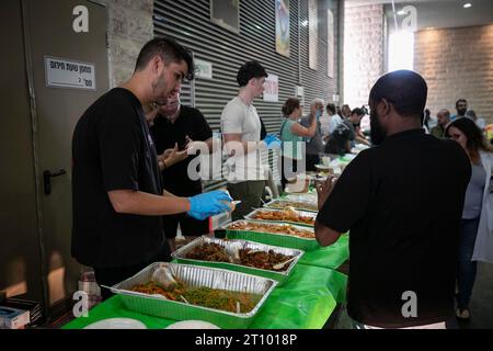 Ashkelon, Israel. 9th Oct, 2023. Volunteers distribute food at a hospital in Ashkelon, south Israel, Oct. 9, 2023. Israel's state-owned Kan TV reported on Monday that at least 900 were killed by Hamas militants in Israel, while the death toll from Israeli airstrikes in Gaza rose to 687, including 140 children and 105 women, according to the Palestinian Health Ministry in Gaza. Credit: Chen Junqing/Xinhua/Alamy Live News Stock Photo