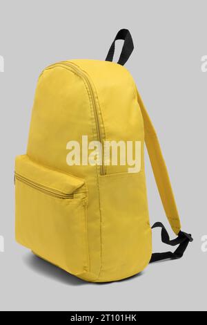 close up trendy fashionable school backpack yellow color isolated on white background with clipping path. side view shoulder strap bag. Stock Photo