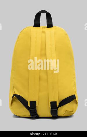 close up trendy fashionable school backpack yellow color isolated on white background with clipping path. back view shoulder strap bag. Stock Photo