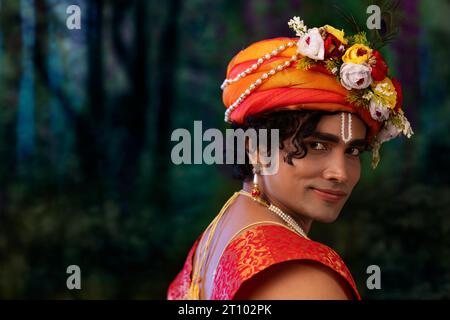 Close-up portrait of young man dressed up as Lord Krishna on the occasion of Janmashtami Stock Photo