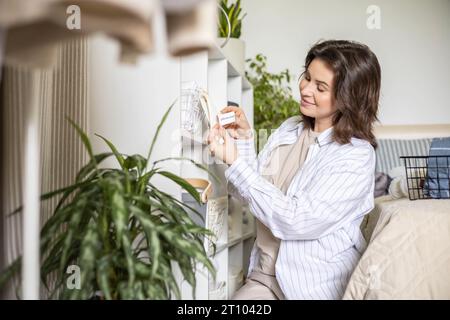 Woman hands organizing cotton pillowcase storage in basket with sticker tag mark at closet shelf Stock Photo