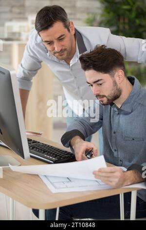 supervisor looking over junior architects work Stock Photo