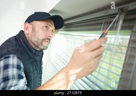 man drilling a hole in a window frame Stock Photo