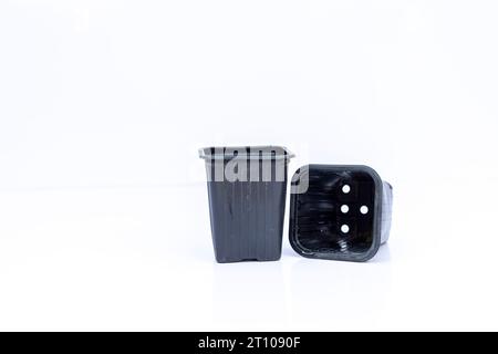 Black plastic flexible containers for seedlings and nursery isolated on white background Stock Photo