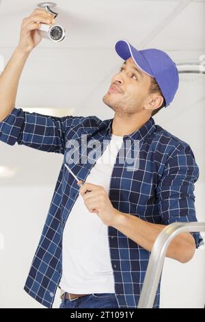 technician man setup cctv camera on wall Stock Photo