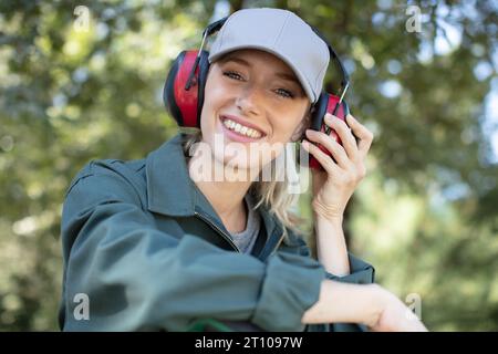 smiling pretty female gardener in hat and helmet Stock Photo