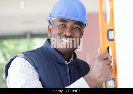 mixed-race construction worker using a spirit level Stock Photo