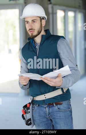 builder checks plans Stock Photo - Alamy