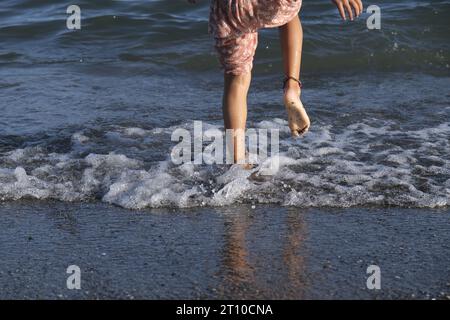 girl jumping on the shore contentedly playing autumn Stock Photo