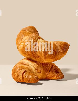 stack of freshly baked croissants on beige background Stock Photo