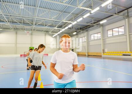 Portrait of smiling girl during training session with friends in gym class Stock Photo