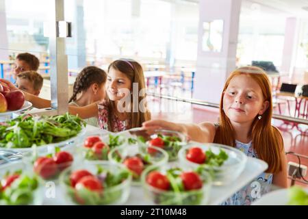 Students reaching for healthy food in school cafeteria Stock Photo - Alamy