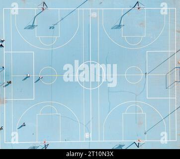 aerial top-down view of a basketball court, painted in vibrant blue. The court's layout and markings are visible Stock Photo