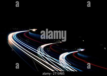 Speed motion at night, busy intersection light vehicle trails on the highway, overpass of the light trails Stock Photo