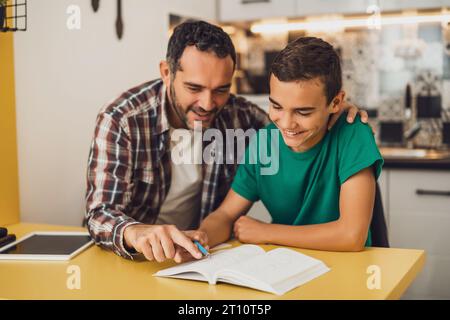 Father is helping his son with learning. They are doing homework together. Stock Photo